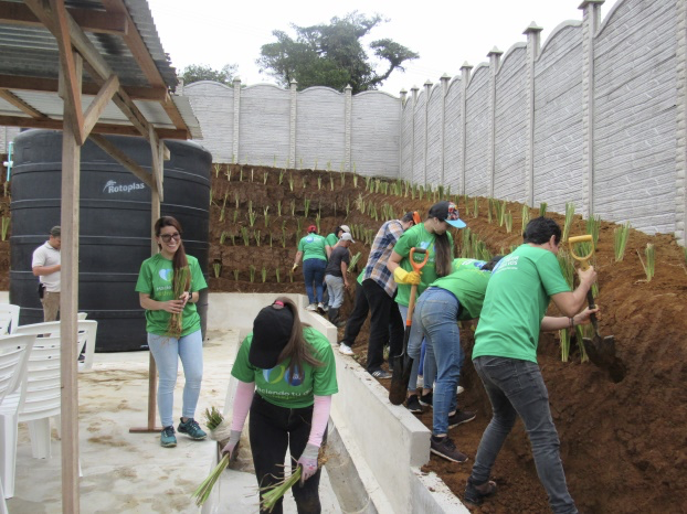 People planting near large water tank